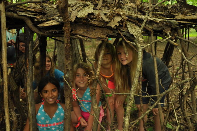 Kids learning how to build an outdoor shelter at camp